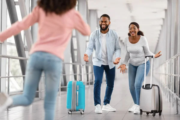 Happy black family meeting running kid in airport — 스톡 사진