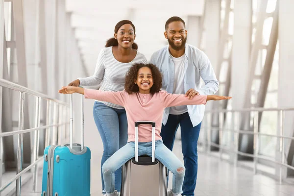 Padres negros felices viajando con su hija, de pie en el aeropuerto — Foto de Stock