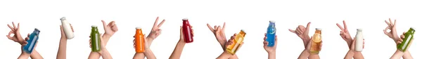 Mãos femininas segurando diferentes sucos saborosos de desintoxicação sobre fundo branco — Fotografia de Stock