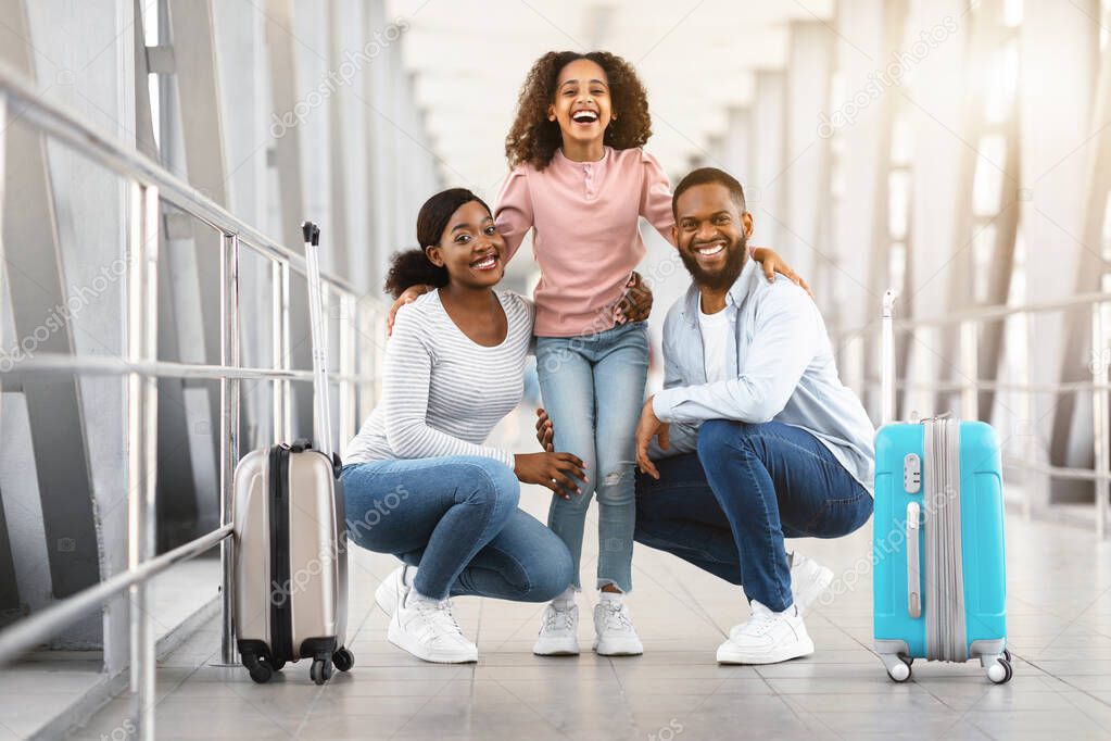 Happy african family traveling, posing together in airport