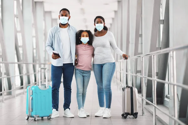 Black family in masks traveling, holding documents posing in airport — 스톡 사진