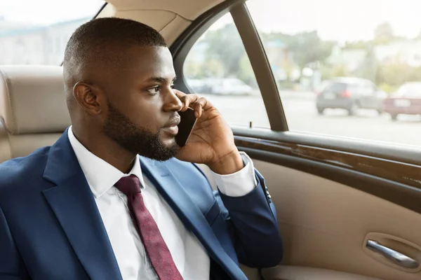 Concentrated black businessman going to business meeting, having phone conversation — Photo