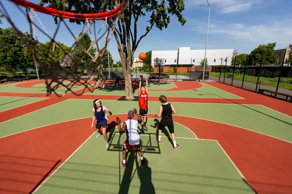Above view of multinational sportsmen playing basketball game at outdoor court, copy space — Stok Foto