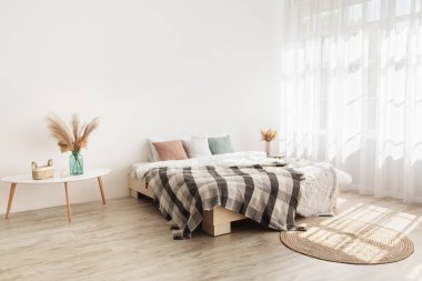 Bedroom interior mockup in boho style with blanket, pillows, white bedding