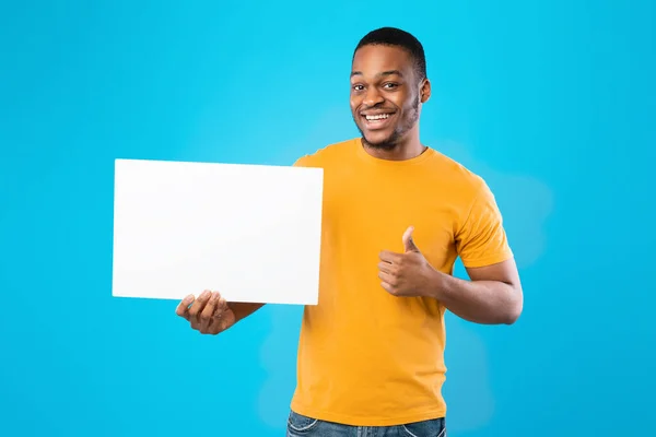 Black Guy Showing Blank White Board Gesturing Thumbs-Up, Blue Background — Zdjęcie stockowe