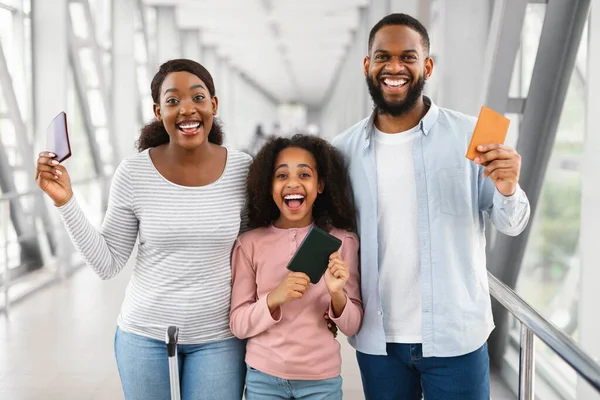 Happy excited black family traveling, holding documents in airport — Stock Photo, Image