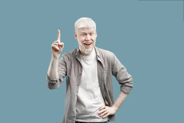Wow, eureka. Young funny albino guy pointing finger up, got solution to his problem, standing on blue background — Stok Foto
