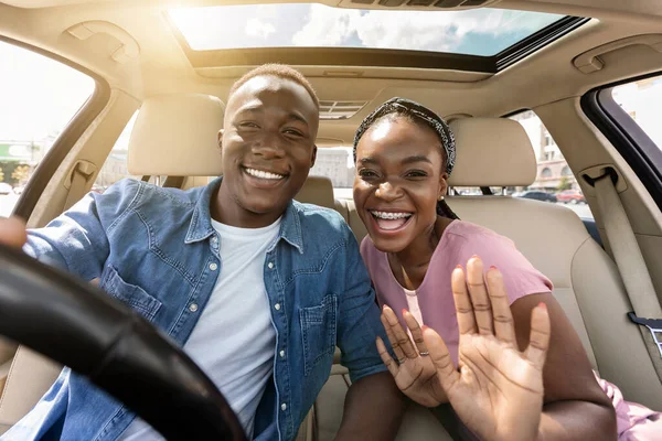 Joyful african american couple taking selfie while having car trip —  Fotos de Stock