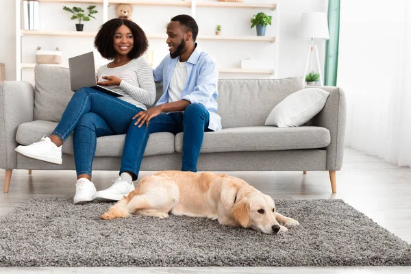 Couple noir à la maison en utilisant ordinateur portable assis avec chien — Photo