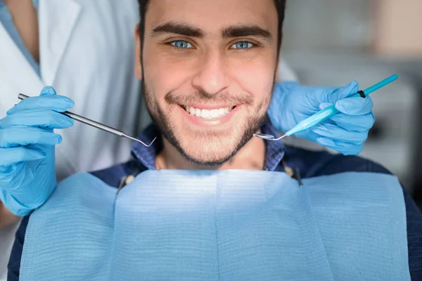 Closeup of handsome young man showing his white teeth