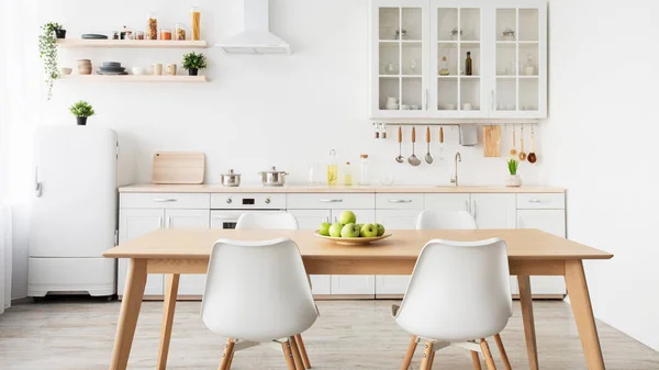 Minimalista konyhai kialakítás. Alma tányér az asztalon, konyhai eszközök és evőeszközök bútoron, panoráma — Stock Fotó