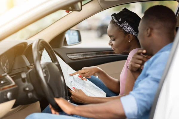 Emocionados viajeros de parejas negras mirando el mapa mientras conducen —  Fotos de Stock