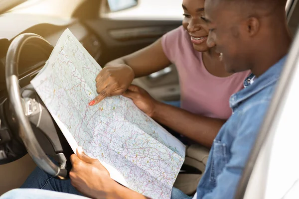 Closeup of map in african american couple hands, car trip