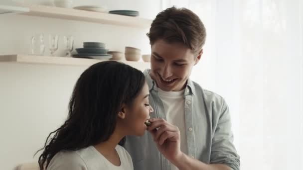 Diversa pareja alimentándose mutuamente cocinando preparando la cena en la cocina — Vídeo de stock