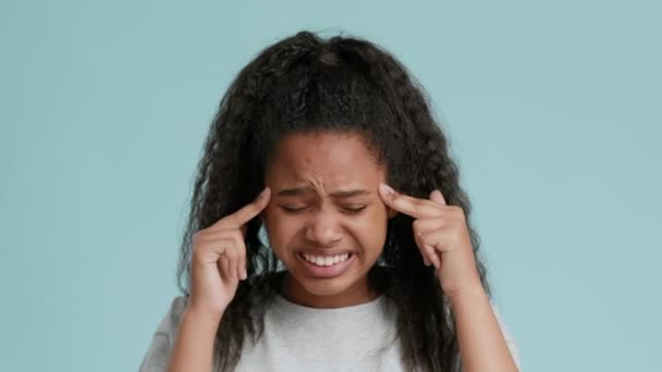 Menina afro-americana perturbada que sofre de dor de cabeça aguda ou ataque de enxaqueca, massagear templos e sorrir — Vídeo de Stock