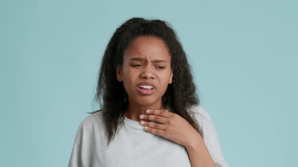 Problemas respiratorios. Retrato de adolescente afroamericana que sufre de dolor de garganta, tocándose el cuello y tosiendo — Vídeos de Stock