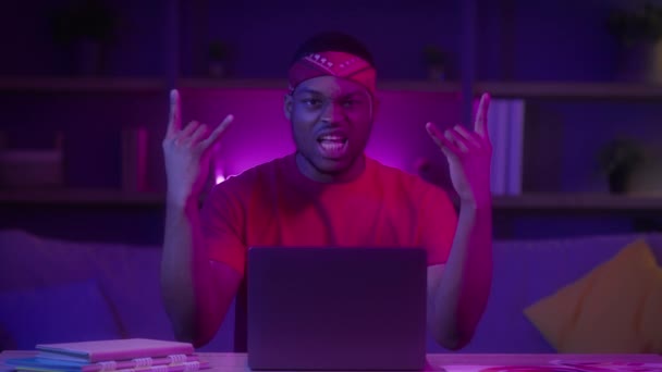 Black Millennial Guy Στο Laptop Εμφάνιση Rock Gesture Κάθεται Εσωτερικά — Αρχείο Βίντεο