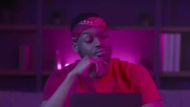 Африканський хлопець на ноутбуці вказуючи пальцем вгору маючи ідею в приміщенні — стокове відео