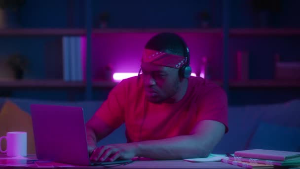 Emotional Black Gamer Guy przegrywa grę online za pomocą laptopa w pomieszczeniach — Wideo stockowe