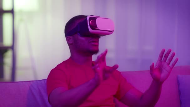 Africký americký tisíciletý muž zažívá virtuální realitu v temném pokoji — Stock video