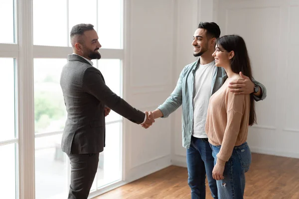Millennial-Paar kauft neue Wohnung und schüttelt Finanzberater die Hand — Stockfoto