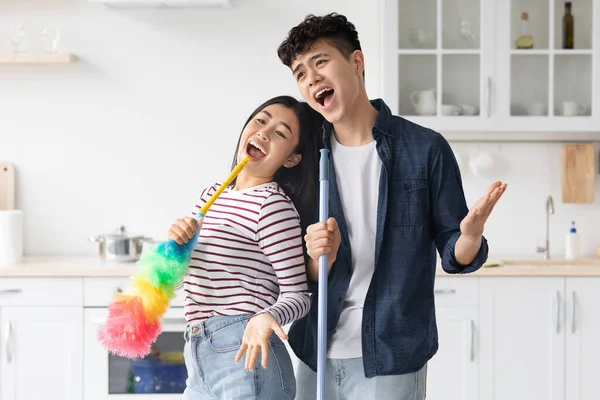 Alegre asiático pareja cantando canciones mientras limpieza cocina — Foto de Stock