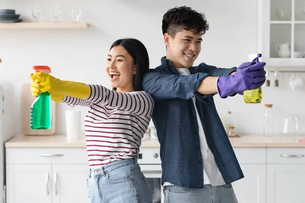 Engraçado asiático casal com limpeza sprays house-keeping — Fotografia de Stock