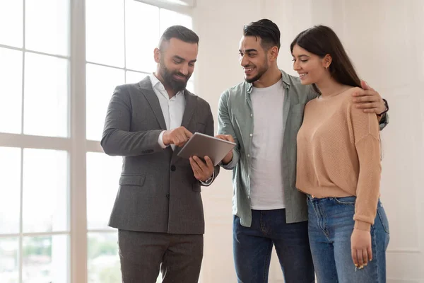 Çift Yeni Apartman Alıyor, Emlakçı Tablet Gösteriyor — Stok fotoğraf