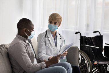 Modern tıbbi bakım, terapist ve fizyoterapist covid-19 sırasında hastayı ziyaret ediyor.