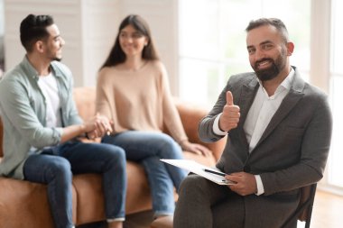 Mutlu çift terapi seansında barışıyor, terapistler onaylıyor.