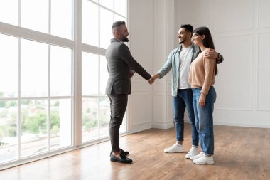 Çift yeni daire alıyor, emlakçıyla tokalaşıyor.