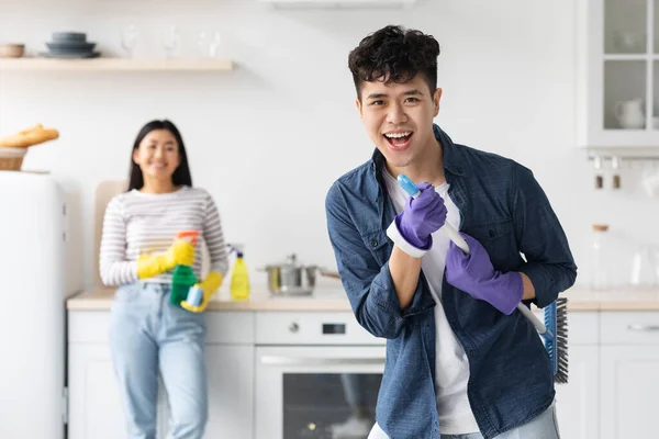 Emocional asiático cara imitando rockstar enquanto house-keeping — Fotografia de Stock