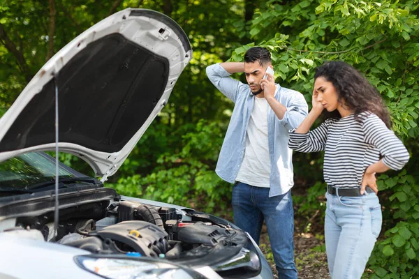 Young arab man calling for help on phone, car break