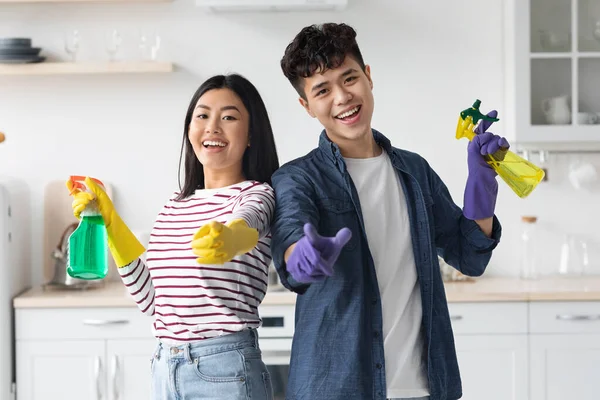Vrolijke aziatische huishoudsters poseren tijdens het schoonmaken van de keuken — Stockfoto