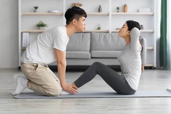 Motivado asiático hombre y mujer trabajando en abdominales en casa —  Fotos de Stock
