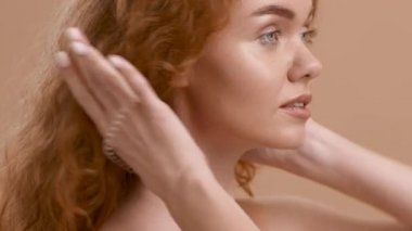 Kızıl Saçlı Kadın 'ın Bej Arkaplan Üzerinde At Kuyruğu Yaparken Görünüşü