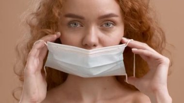 Kadın, Bej Arkaplan Üzerine Koruyucu Yüz Maskesi Takıyor