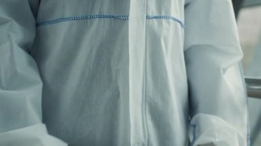 Havaalanında tehlikeli madde giysisi ve eldiven giyen tıbbi işçiler.