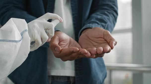 Irriconoscibile medico lavoratore spruzzando Sanitizer sulle mani turistiche in aeroporto — Video Stock