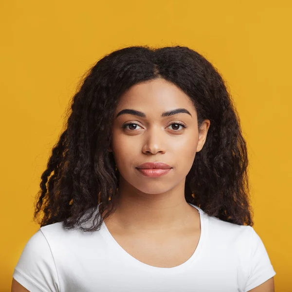 Belleza natural. Retrato de una joven afroamericana con hermoso cabello rizado, posando sobre fondo amarillo — Foto de Stock