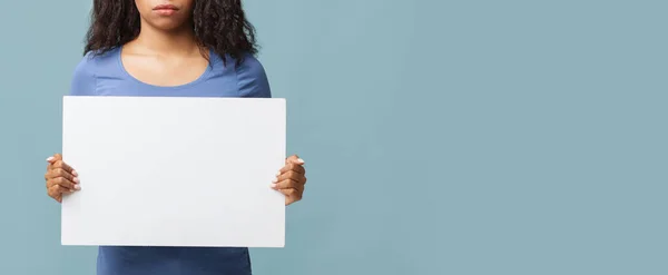 Reklamınız için yer var. Tanımlanamayan Afrikalı Amerikalı kadın elinde mavi arka planda boş bir pankart tutuyor. — Stok fotoğraf