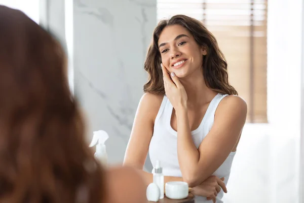 Красивая леди касаясь лица с идеальной гладкой кожей в ванной комнате — стоковое фото