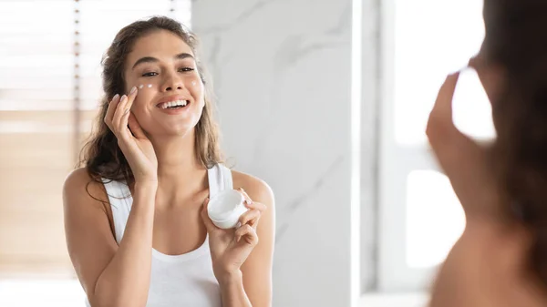 Lady Moisturizing Kulit Menerapkan Krim Pada Wajah di Kamar Mandi, Panorama — Stok Foto