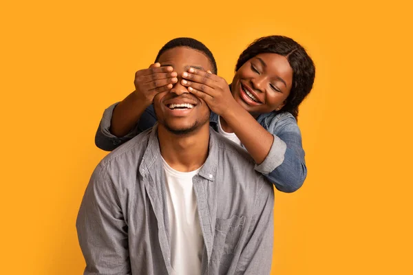 Lycklig afrikansk kvinna överraskar sin upphetsade pojkvän, täcker hans ögon — Stockfoto