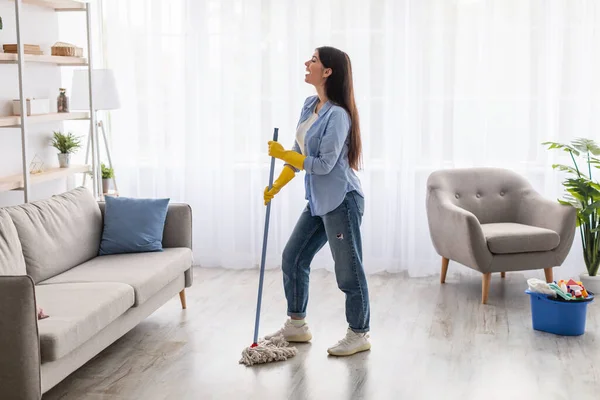 Portrait of woman cleaning floor singing holding mop — Stock Photo, Image