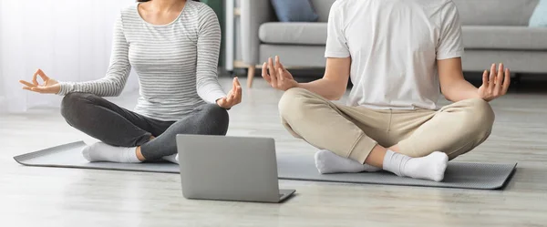 Cropped of young couple practicing yoga at home — стоковое фото