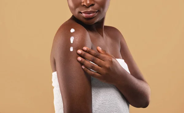 Skin Mousturising Concept. Fechar tiro de jovem mulher negra aplicando loção corporal — Fotografia de Stock