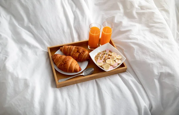 Café da manhã saudável para dois com suco de laranja, croissants e cama de granola, acima da vista. Refeição romântica para os amantes conceito — Fotografia de Stock