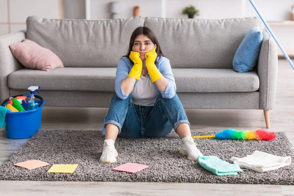 Verontrustende vrouw moe van het schoonmaken zitten op vloerkleed — Stockfoto