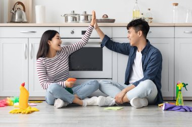 Mutfakta oturan mutlu Asyalı çift beşlik çakıyor.